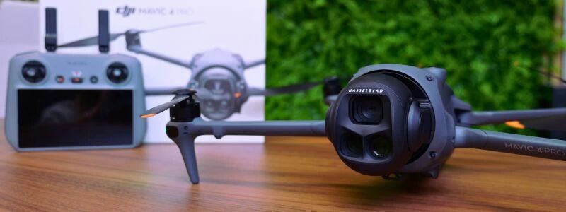 Drone DJI Mavic 4 Pro avec radiocommande et packaging, posé sur une table en bois